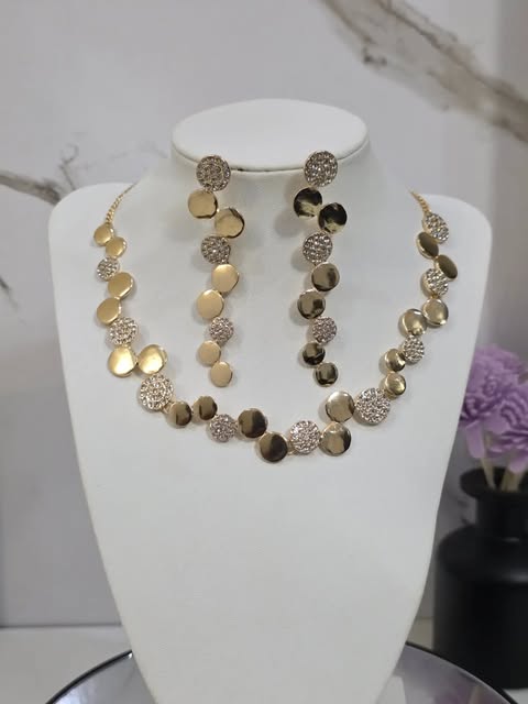 Fredelle Jewels gold disc necklace and matching drop earrings on a white display bust